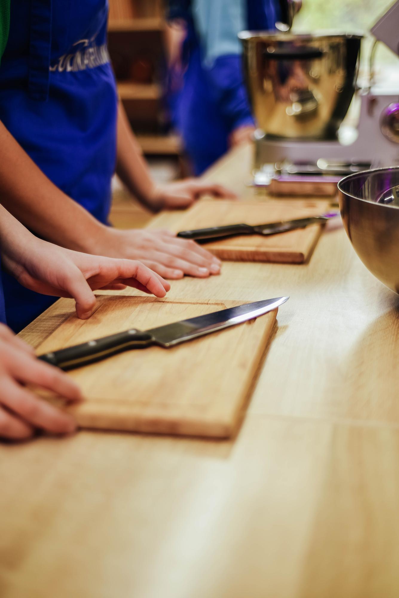 Small group in a countertop kitchen practicing knife skills